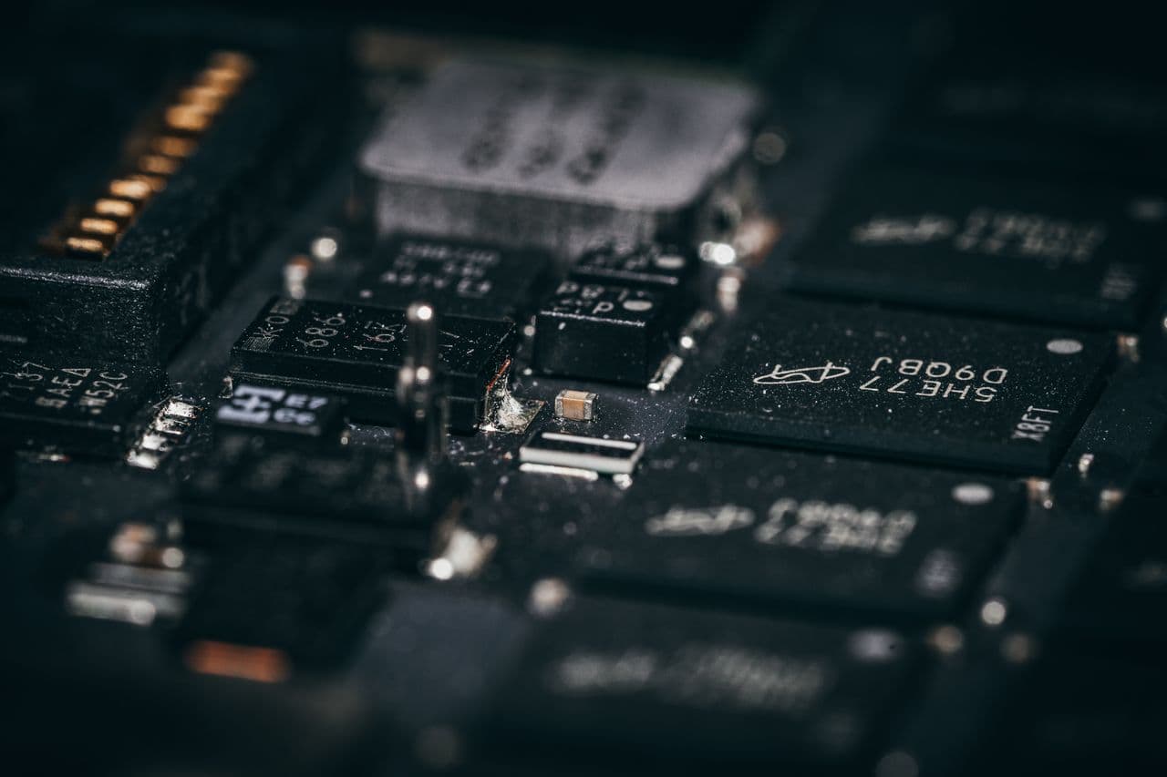 Close-up precision electronics assembly — SMD components on dark PCB for cleanroom manufacturing.
